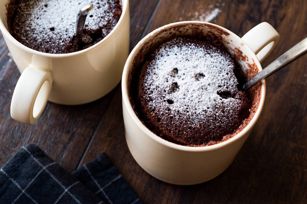 Microwave Brownie Chocolate Mug Cake with Powder Sugar on Dark Wooden Surface. - Foto, imagen