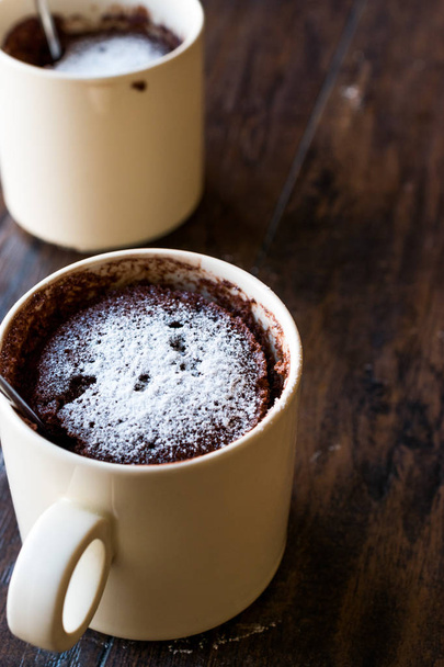 Microwave Brownie Chocolate Mug Cake with Powder Sugar on Dark Wooden Surface. - 写真・画像