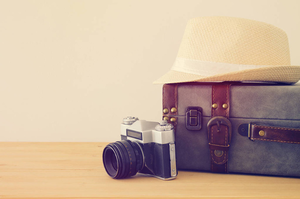 traveler vintage luggage, camera and fedora hat over wooden table. holiday and vacation concept. - Fotoğraf, Görsel