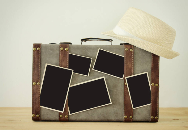 Image of old vintage luggage, fedora hat and blank photos for photography montage mockup over wooden floor. - Φωτογραφία, εικόνα