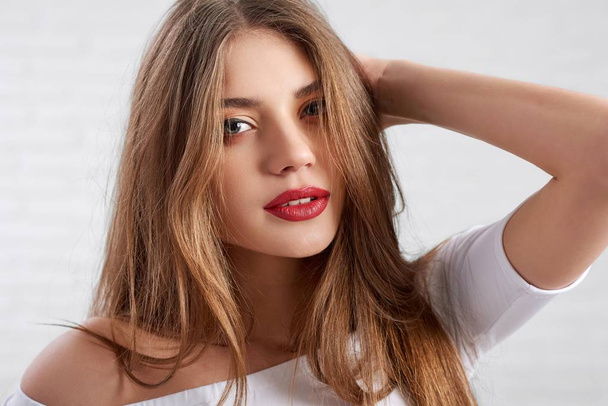 Attractive Caucasian female model in white top wearing eye make up and red lipstick - Foto, Imagen