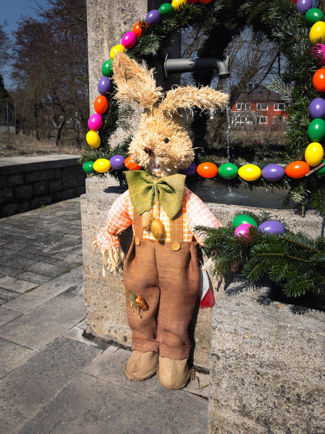 Easter bunny in front of an easter fountain - Photo, Image