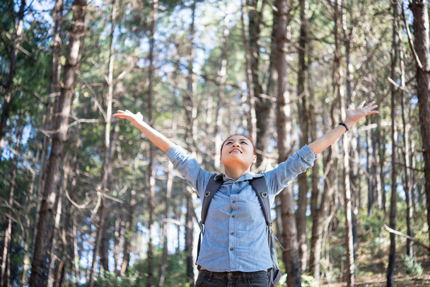 Jeune femme heureuse hipster profiter de la nature dans la forêt avec les bras tendus
. - Photo, image