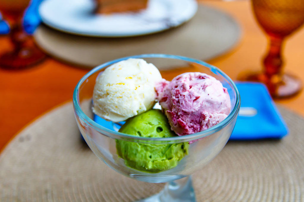 Tres cucharadas de helado: pistacho, vainilla, bayas en una copa
 - Foto, imagen