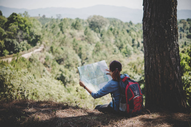 Genç kadın backpacker uzun yürüyüşe çıkan kimse okuma harita gezi uzağa gitmek için yer bulmak isteyen hiking. Macera tatili. - Fotoğraf, Görsel