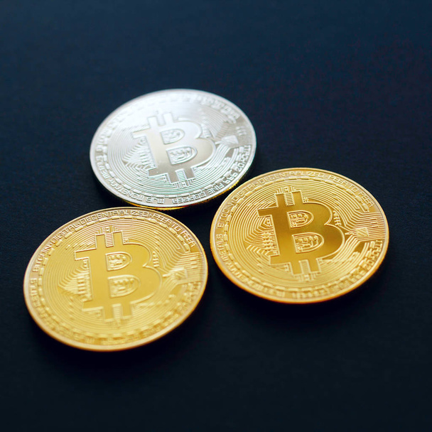 Picture of three gold bitcoin over black background. Digital mon - Foto, Imagem