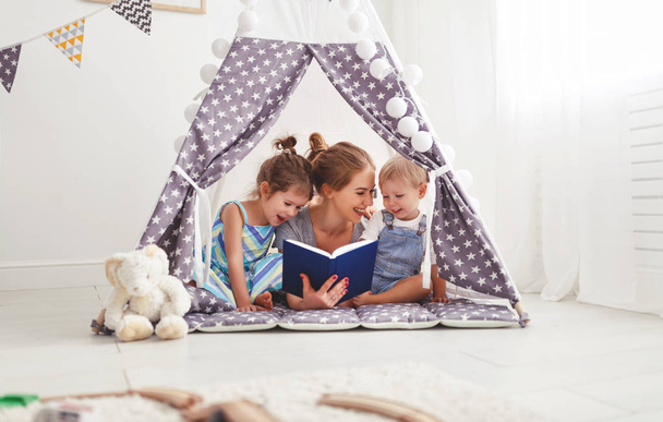 Rodzina Matka czytania książki dzieci w namiocie w hom - Zdjęcie, obraz