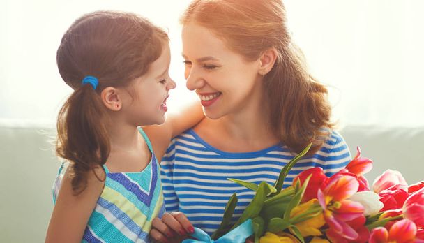 happy mother's day! child daughter   gives mother a bouquet of f - Photo, Image