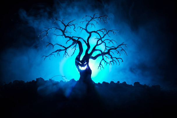 Siluetti pelottava Halloween puu kauhu kasvot tumma sumuinen äänisen tausta kuun takana puolella. Pelottava kauhu puu zombie ja demoni kasvot
. - Valokuva, kuva