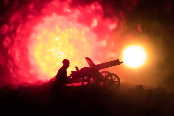 夜、火災爆発背景または戦争の霧空の背景夜曇りスカイライン以下世界大戦兵士のシルエットのシーンをかけて戦う軍事シルエット マシン銃を持つ男. - 写真・画像