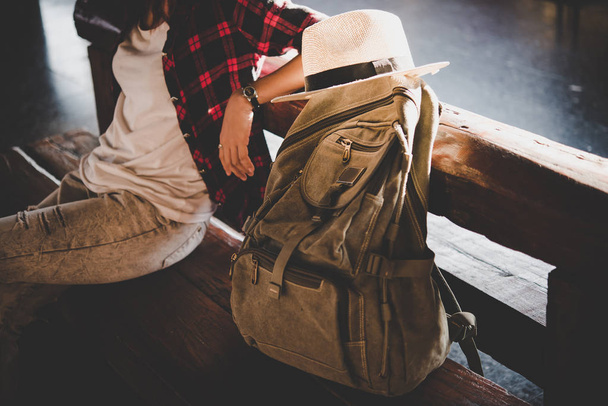 Young hipster tourist woman with backpack sitting in the train station. Holiday tourist concept. - Photo, Image