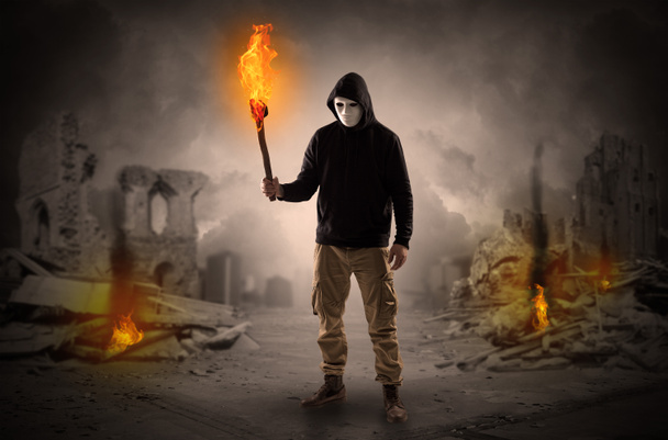 Man coming with burning flambeau at a catastrophe scene concept - Photo, Image