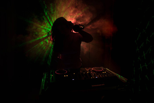 DJ předení, míchání a poškrábat v nočním klubu, ruce dj vylepšovat různé skladby ovládací prvky na dj deck, výstražná světla a mlha, nebo Dj mixy trati v nočním klubu na party - Fotografie, Obrázek