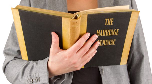 Woman reading a marriage almanac - Photo, Image