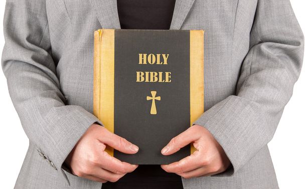 Woman in business suit is holding a holy bible - Foto, imagen
