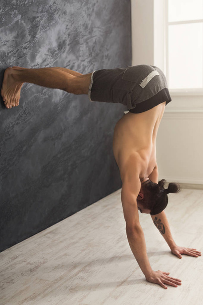 Young man practicing yoga with gymnastic mat - Photo, Image
