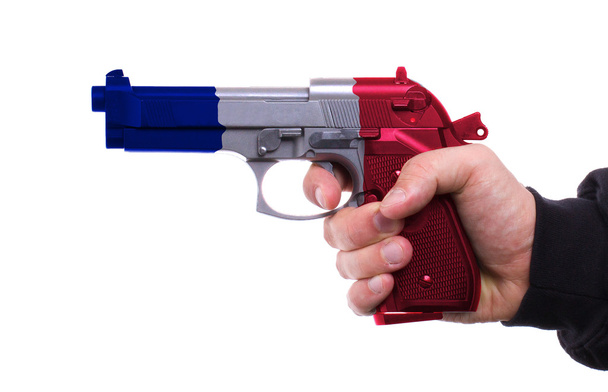 πιστόλι με γαλλική σημαία μοτίβο στο χέρι - Φωτογραφία, εικόνα