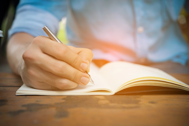 Man Hand schrijven op de notebook. - Foto, afbeelding