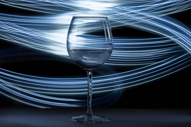 Wine glass on the table, in the background light brush                                - Фото, изображение
