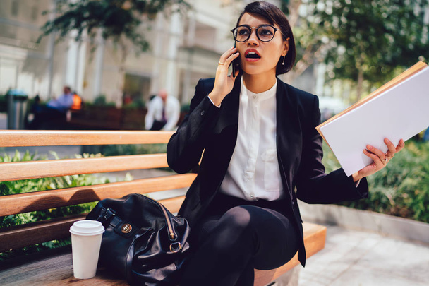 Worried female entrepreneur shocked with financial news of company during mobile conversation on smartphone device.Stressed trader disappointed with last business event talking on cellphone - Foto, Imagem