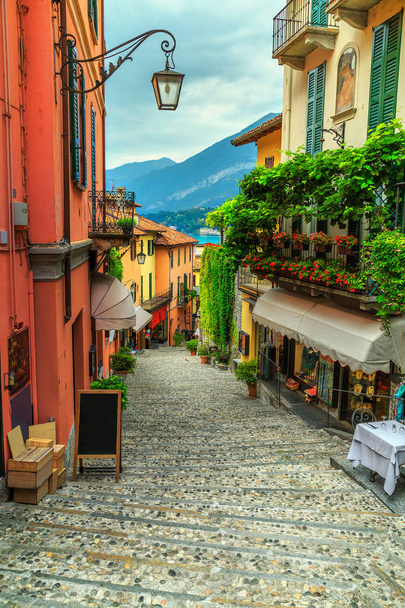 Impresionante calle panorámica con casas coloridas y flores en Bellagio
 - Foto, Imagen