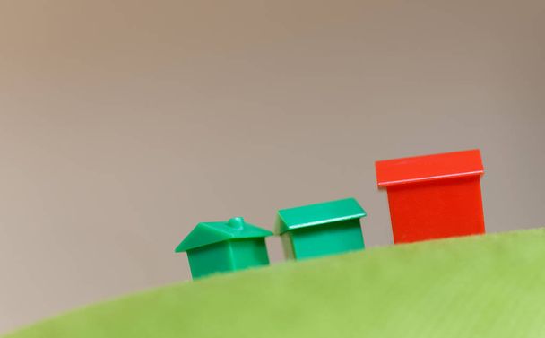 Monopolio en miniatura casas en la parte superior de una altura verde
 - Foto, Imagen