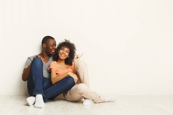 Afro-amerikai házaspár, átölelve, ülő földre - Fotó, kép