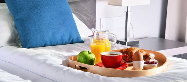 Breakfast on tray in bed in hotel room - Φωτογραφία, εικόνα