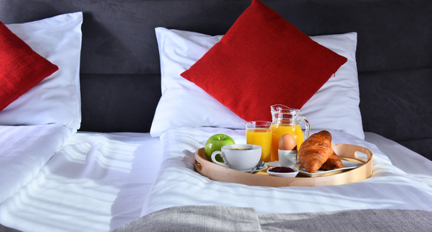 Śniadanie na tacy w łóżku w pokoju hotelowym - Zdjęcie, obraz