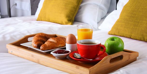 Πρωινό στο δίσκο στο κρεβάτι στο δωμάτιο του ξενοδοχείου - Φωτογραφία, εικόνα