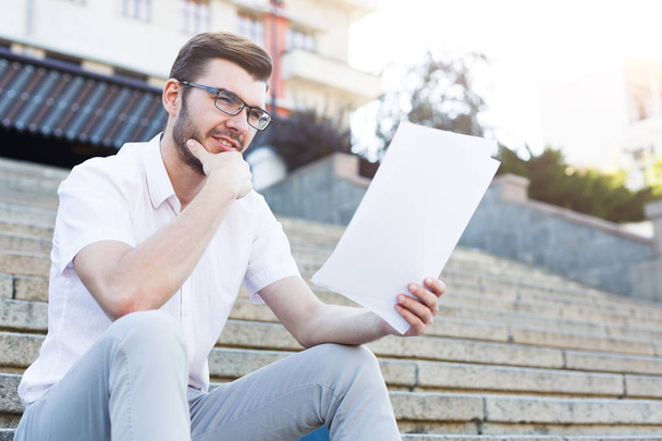 Pensive man reading the documents outdoors - Foto, Imagem