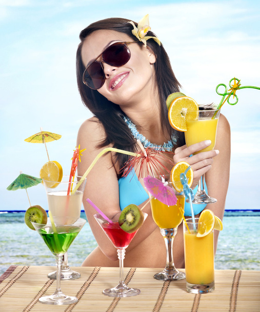 Дівчина в бікіні на пляжі п'є коктейль
. - Фото, зображення