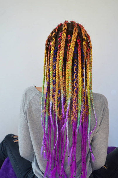 Une fille avec un ensemble à la mode de tresses multicolores Kanekalon. Brins artificiels colorés de cheveux. Matériel pour tressage
  - Photo, image