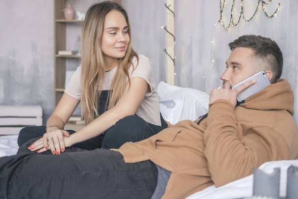 Elegante casal hipster de homem e mulher sentado na cama em sua
  - Foto, Imagem