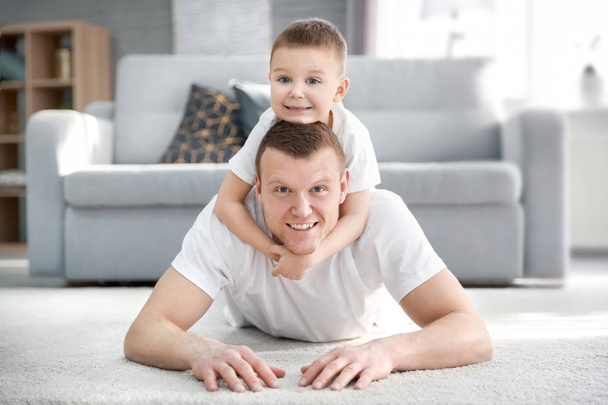 Happy dad and his son at home. Father's day celebration - Фото, изображение
