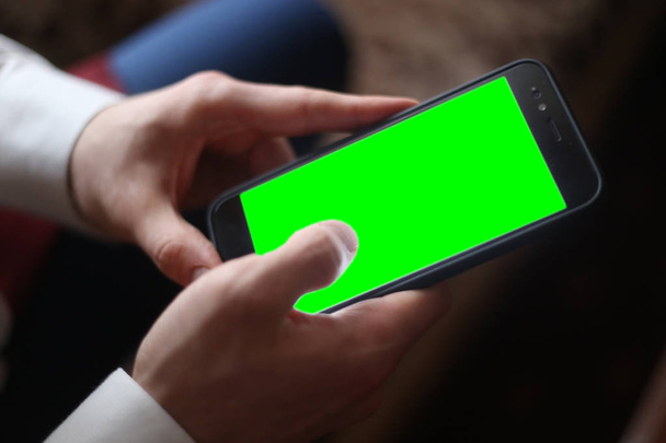 smartphone negro con pantalla verde en las manos de los hombres
 - Foto, Imagen