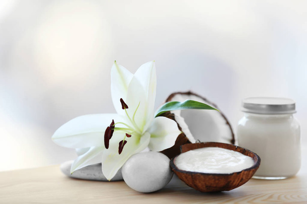 Samenstelling met kokos boter in glazen pot en shell op onscherpe achtergrond - Foto, afbeelding