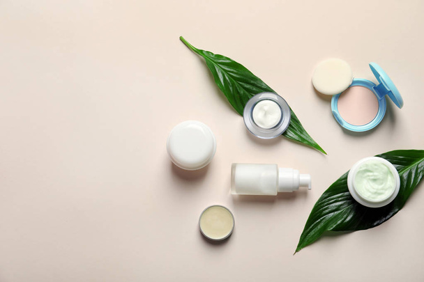 Different skin care cosmetic products with green leaves on light background, top view - Foto, afbeelding