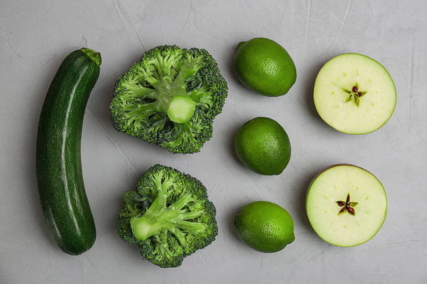Different green vegetables and fruits on grey background, top view - Foto, imagen