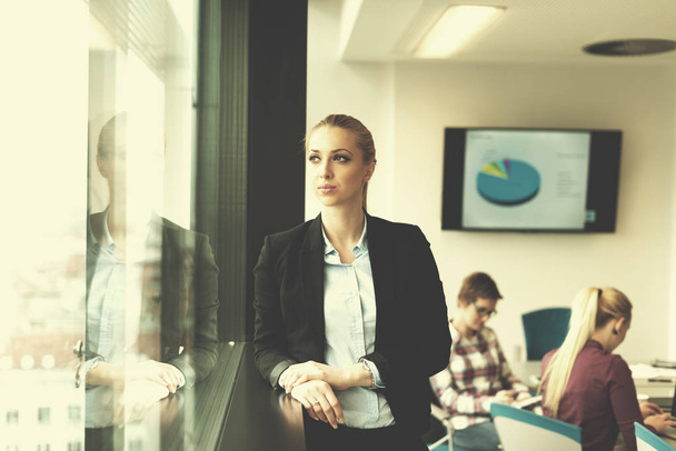 portrait of young business woman at modern startup office interior, team in meeting group in background - Fotografie, Obrázek