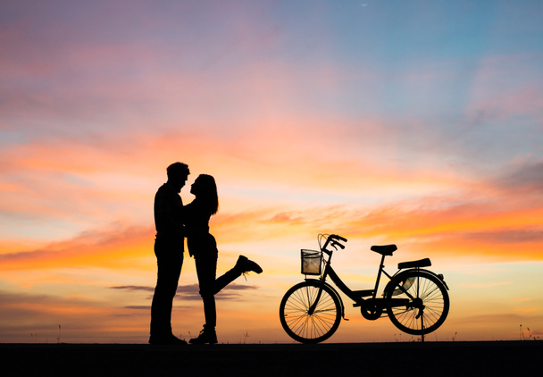Silueta mladý pár v lásce mají dobrý čas společně při západu slunce. - Fotografie, Obrázek