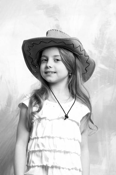 child, little smiling girl in cowboy hat on colorful background - Fotó, kép
