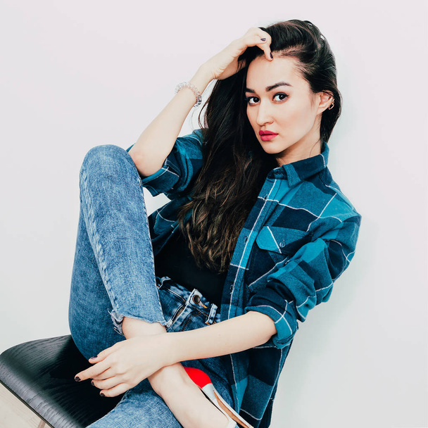 Beautiful brunette with long hair in checkered shirt. Casual loo - 写真・画像