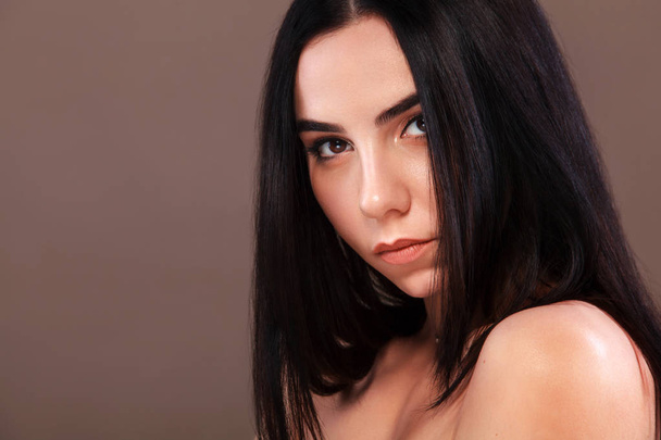 Closeup portrait of a beautiful woman. Pretty face of the young adult girl. Fashion model posing at studio. Cosmetology and spa concept. - Foto, Imagen