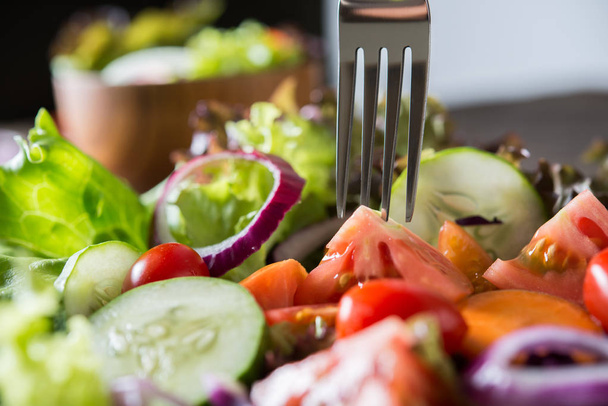 Primer plano de ensalada de verduras frescas en el tazón con fondo rústico de madera vieja. Concepto de comida saludable. - Foto, imagen
