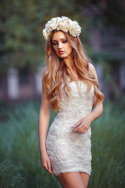 A pretty young blonde woman in summer dress in nature - Foto, Imagem