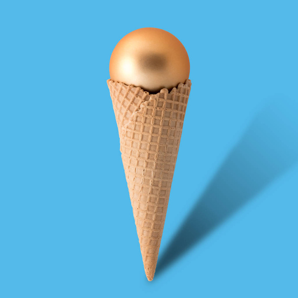Ice cream cone with christmas ball on bright blue background.  - Foto, afbeelding