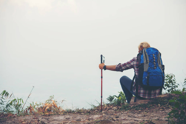 Joven hipster excursionista con mochila sentado en la cima de la montaña
. - Foto, Imagen