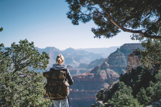 Giovane hipster ragazza vagabondaggio trascorrere il fine settimana per esplorare il Parco Nazionale del Grand Canyon escursioni con zaino, turista femminile in terra selvaggia con colline arrivare a destinazione godendo vista paesaggio natura
 - Foto, immagini