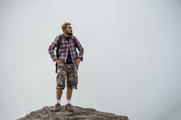Hiker with backpacks standing on top of a mountain and enjoying nature view. - Valokuva, kuva